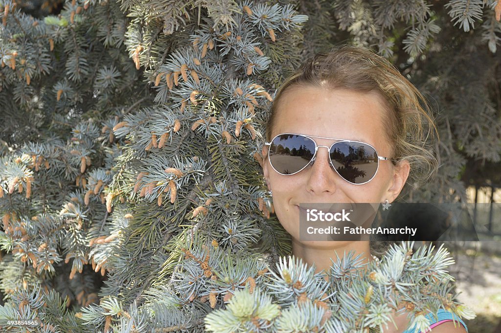 Beautiful girl in branchs of blue spruce Child Stock Photo