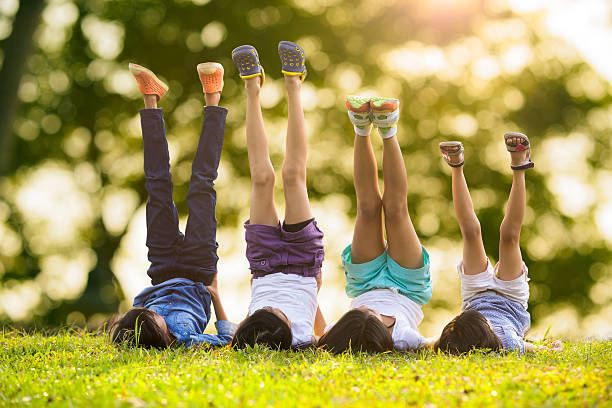 istock Group of happy children lying on green grass 493854705