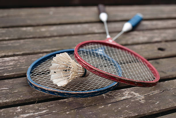 istock two badminton rackets on the old wooden table 493855889