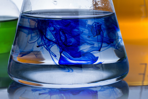 chemistry laboratory equipment and blue drop in the liquid in the flask