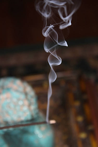 Burning Incense with Smoke Swirls stock photo
