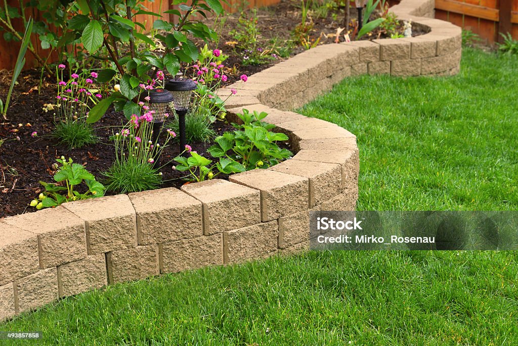 stone wall with perfect grass landscaping in garden with artificial grass Artificial Stock Photo