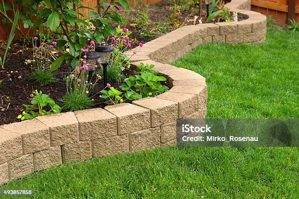 Stone Wall With Perfect Grass Landscaping In Garden With Artificial Grass Stock Photo - Download Image Now