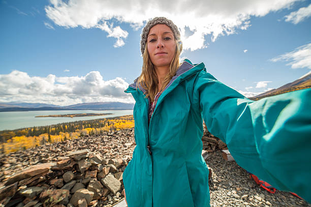 istock Young woman on mountain top taking selfie portrait 493858564