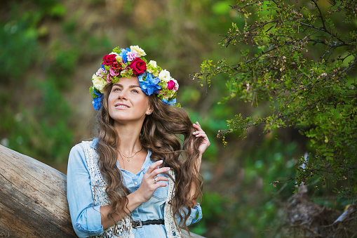 Portrait of a beautiful girl with a diadem of a flowers on a head