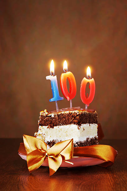 istock Piece of Cake with Burning Candle as Number One Hundred 493863320