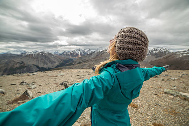 istock Hiker reaches mountain top outstretches arms 493865090