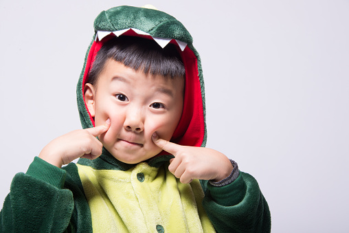 Asian boy acting dinosaur in white background