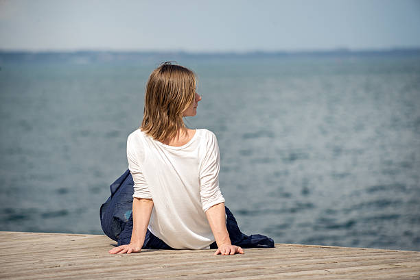 istock Woman sitting at the beach 493867124
