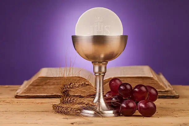 chalice  and holy bible on table