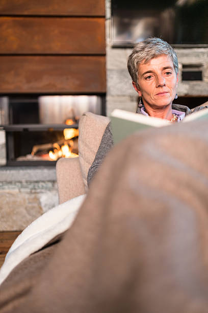 istock woman reading a book on the couch 493879948