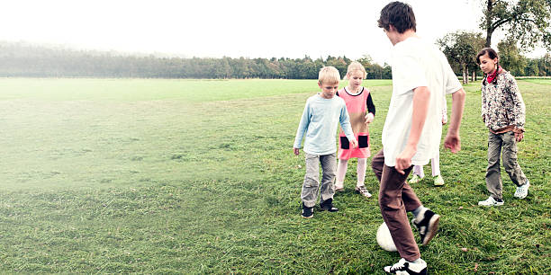istock Young boy playing soccer with friends 493880486