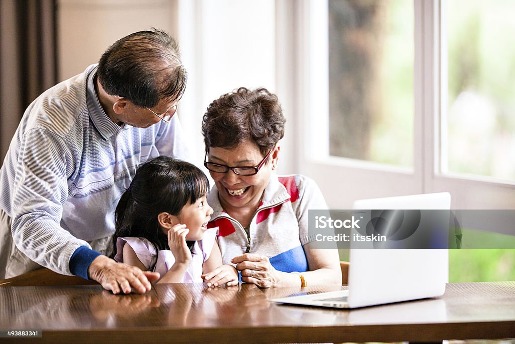 孫娘、おじいちゃん、おばあちゃんノートパソコンを使う - 3人のロイヤリティフリーストックフォト