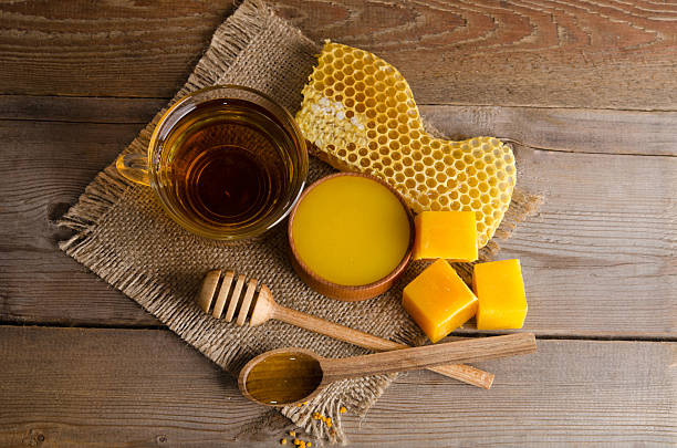 Still life from cup of tea, honey, wax and honeycombs Still life from cup of tea, honey, wax and  honeycombs on wooden table. studio photo top view honeycomb animal creation photos stock pictures, royalty-free photos & images