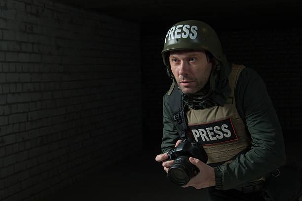 istock Photojournalist in a helmet and flak jacket 493884308