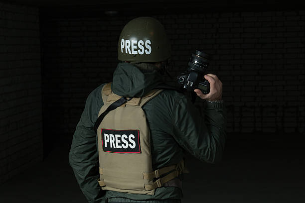 istock Photojournalist in a helmet and flak jacket 493884404