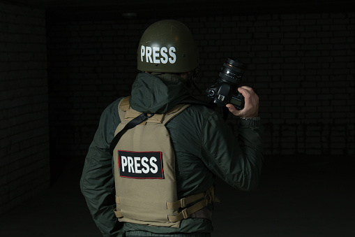 Photojournalist in a helmet and flak jacket
