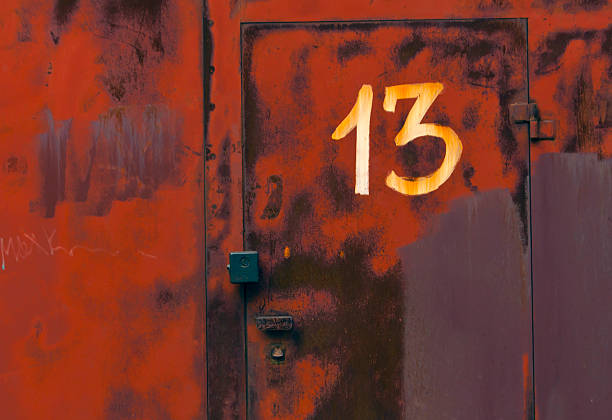 istock Number thirteen on red metal locked door. 493884522
