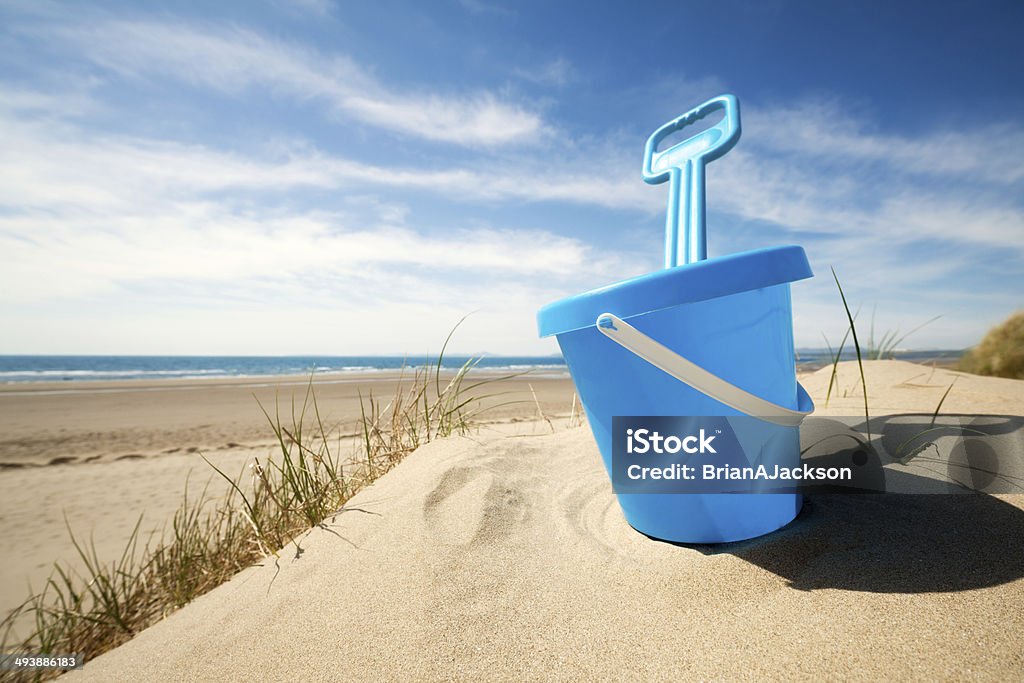 Beach bucket and spade Childs bucket and spade or sand pail and shovel at the beach on a sunny summer day Bucket Stock Photo