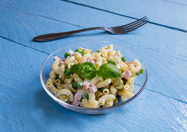 istock Pasta salad in a glass bowl on blue wood 493887563