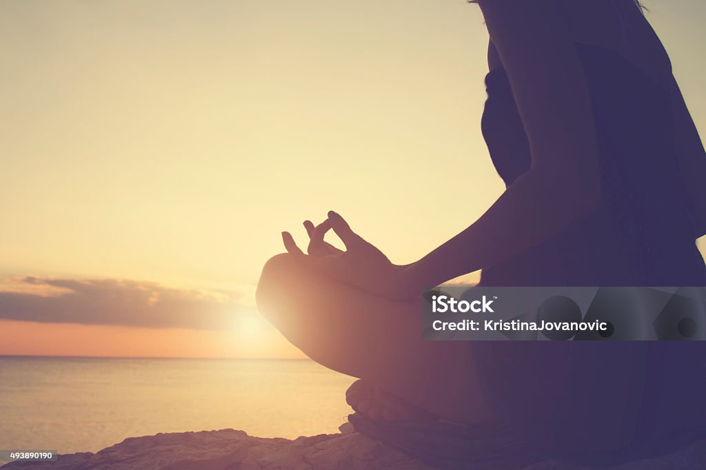 Young woman practicing yoga on the beach. 2015 Stock Photo