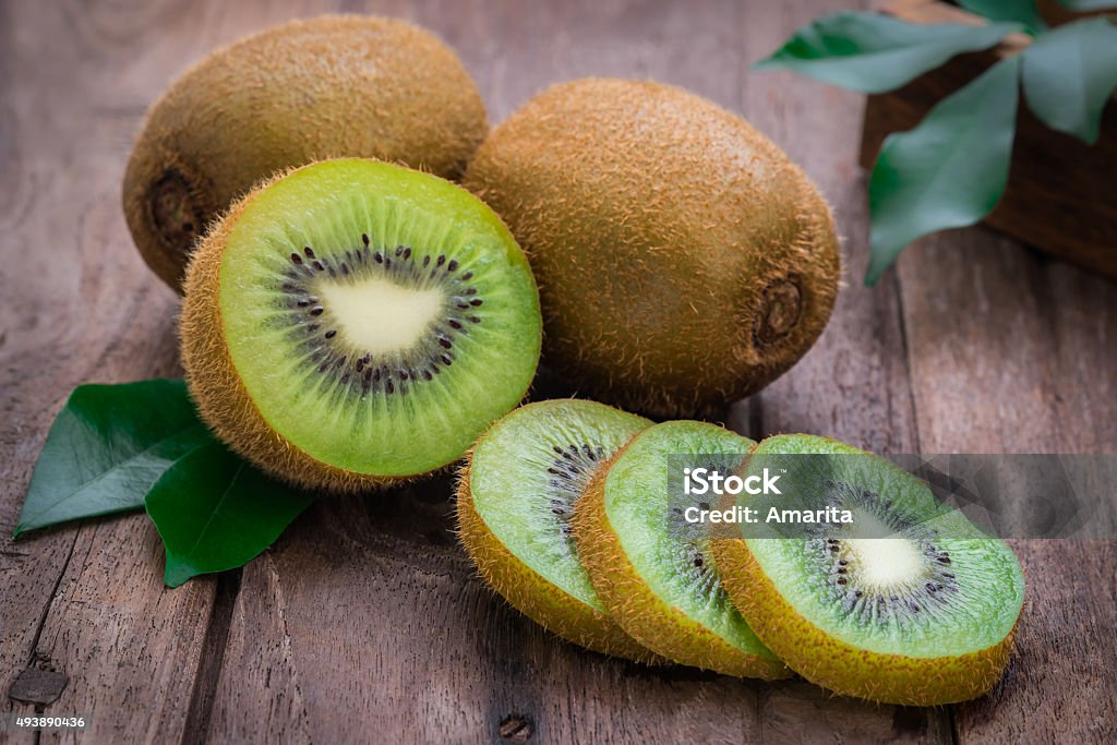 Kiwi fruit slices on wooden table Kiwi Fruit Stock Photo