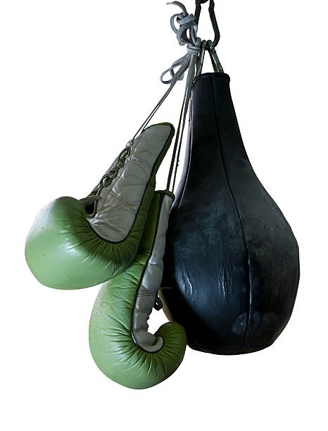 old boxing gloves and punching bag hang on hook