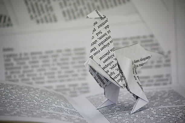istock Origami dinosaur coming out of a book 493903256
