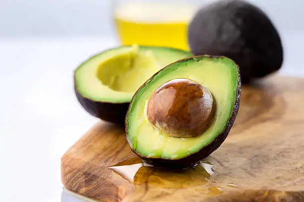 ripe avocado cut in half on a wooden table 
