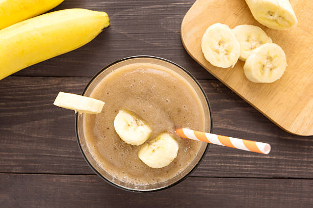 istock Banana smoothie on wooden background. Top view 493908048