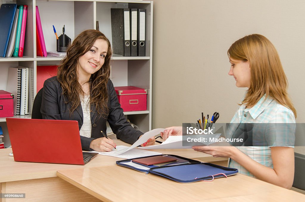 Head gladly sign the documents prepared by the expert Young beautiful girl on reception at the office specialist 2015 Stock Photo