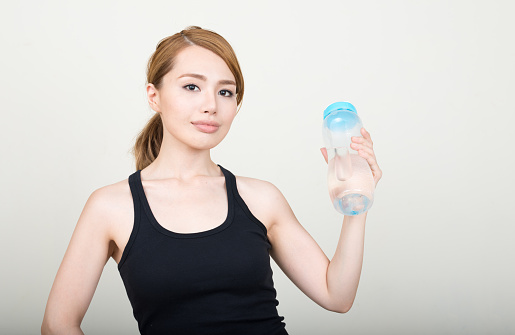 Asian woman holding waterbottle horizontal studio shot