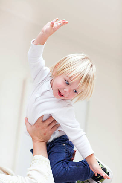 istock beautiful blond boy playing in his mother's arms 493910666