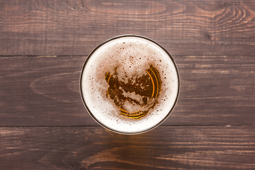 glass of beer on a wooden background. Top view.