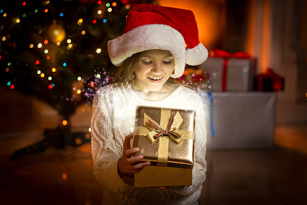 istock little girl posing with glowing golden gift box 493913906