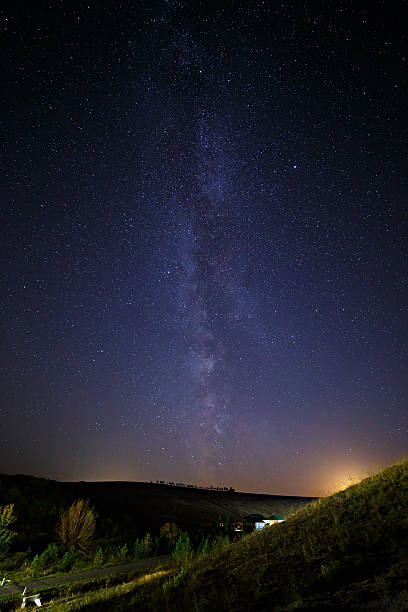 istock starry sky and Milky Way  above the lighted lanterns city. 493913972