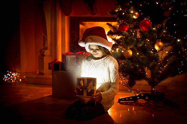 istock cute girl sitting on floor and holding present box 493914014