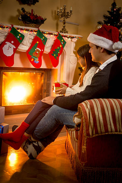 istock Father and daughter sitting at fireplace decorated for Christmas 493914498