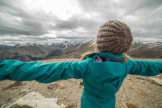 istock Hiker reaches mountain top outstretches arms 493914506