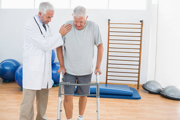 istock Doctor assisting senior man walking with zimmer frame 493915733