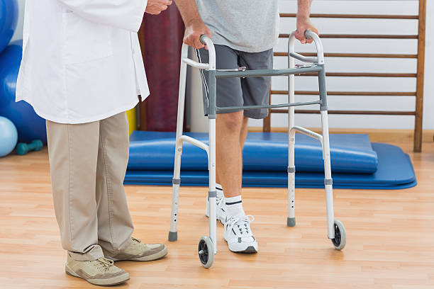 istock Doctor assisting man walking with zimmer frame 493915737