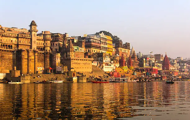 the city and the ghats of Varanasi in the early morning at sunrise. (all logos blurred)