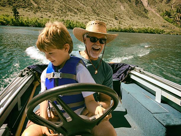 istock Child driving a boat with Grandpa 493916756