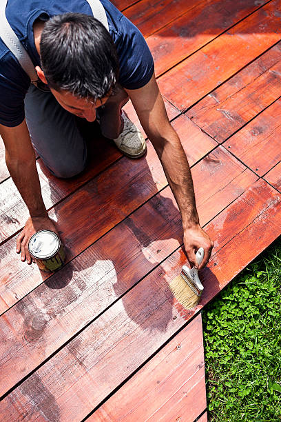 adulto joven pintura la terraza - wood deck wood stain paint fotografías e imágenes de stock