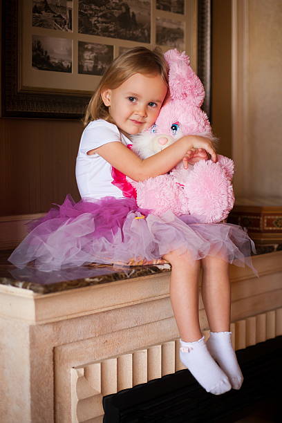Garota em Saia cor-de-rosa com brinquedos macios - foto de acervo