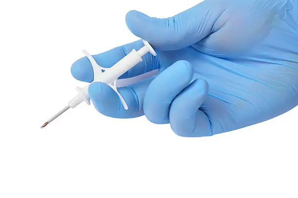 Photo of hand holding syringe