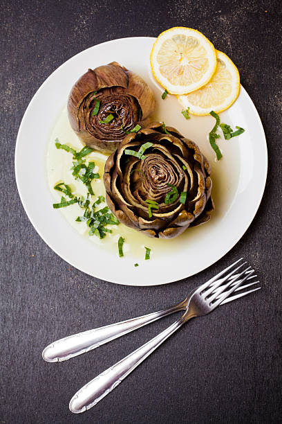 фаршированные артишоки на тарелке с лимоном - artichoke artichoke heart salad portion стоковые фото и изображения