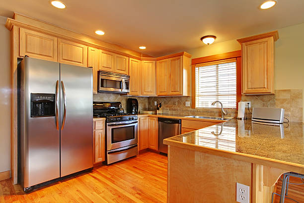 istock Golden maple cabinets kitchenw with new appliances. 493920279