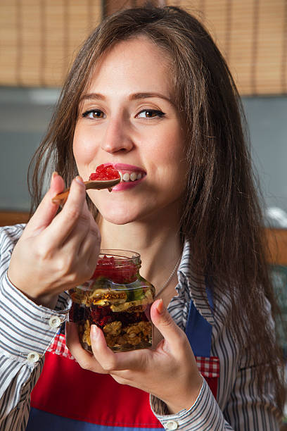 istock Woman eating dried fruit mix with honey topping. 493928948