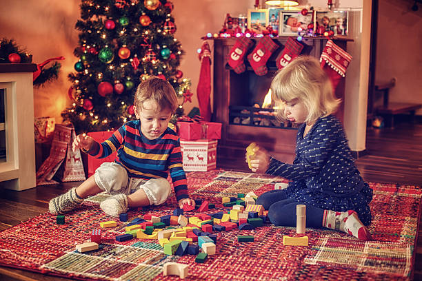 istock Adorable Kids Playing in in front of Christmas Tree 493930382